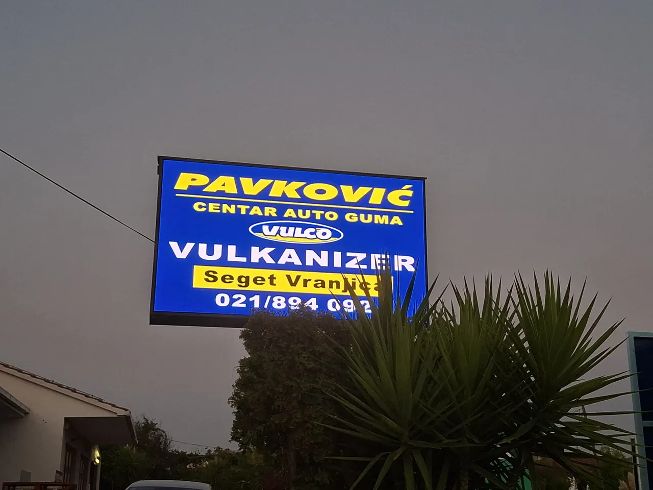 LED ekran u sumrak, s plavom reklamom centra auto guma