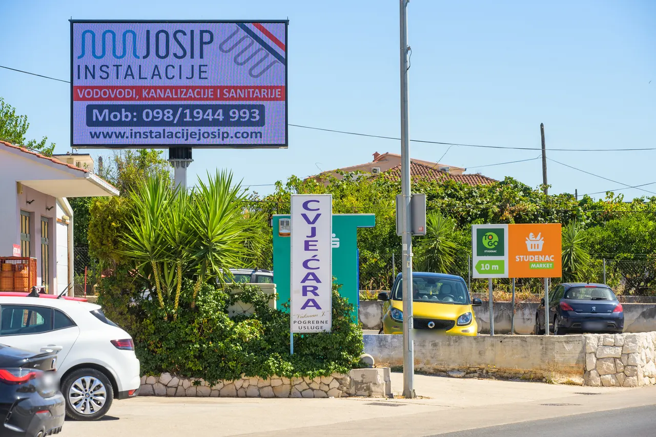 LED ekran uz cestu, kod trgovine Studenac, danju